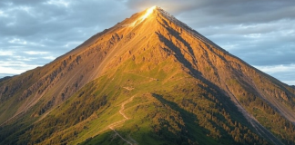 Mentalidad Ganadora: Cómo Prepararse Psicológicamente para Competir en Golf Montaña con un pico brillante, iluminado por la luz del amanecer, simbolizando el esfuerzo y la superación personal.