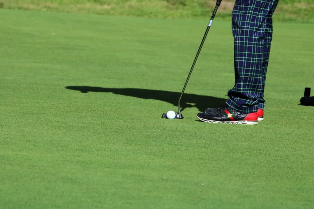 Jugador de golf en posición de putt con postura correcta y putter alineado