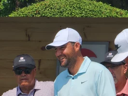 Scottie Scheffler caminando con seguridad en el campo de golf, reflejando su concentración y disciplina.