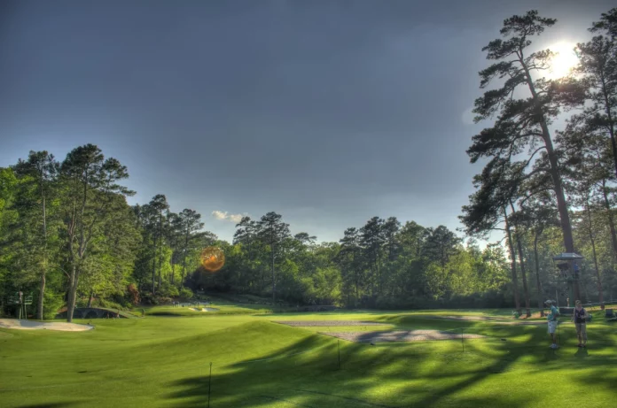 Vista panorámica del Amen Corner en Augusta National Golf Club con sus puentes, búnkers y vegetación primaveral.