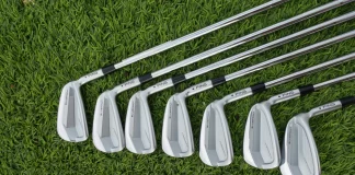 Juego de hierros de golf del 3 al 9 alineados sobre el césped