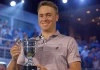 Justin Thomas: Un Compromiso con la Preparación Física y Mental Imagen generada de Justin Thomas recibiendo un trofeo tras una victoria en un torneo de golf, celebrando su éxito.