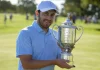 Patrick Cantlay: Un Enfoque Meticuloso en su Rutina de Entrenamiento Patrick Cantlay recibiendo un trofeo en reconocimiento a su victoria en un torneo de golf, destacando su dedicación y talento.