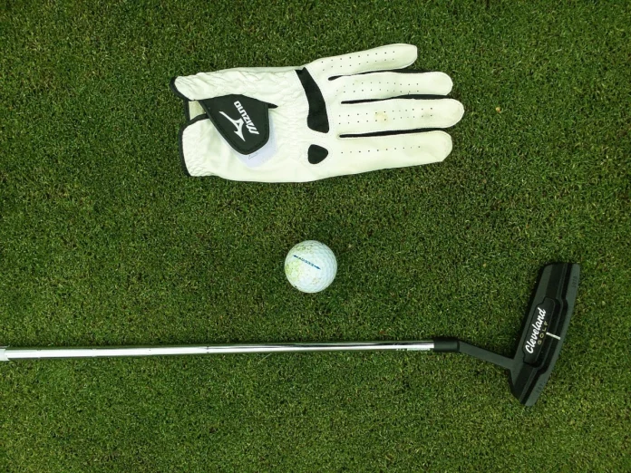 Putter Cleveland tumbado en el green con la bola preparada para el golpe.