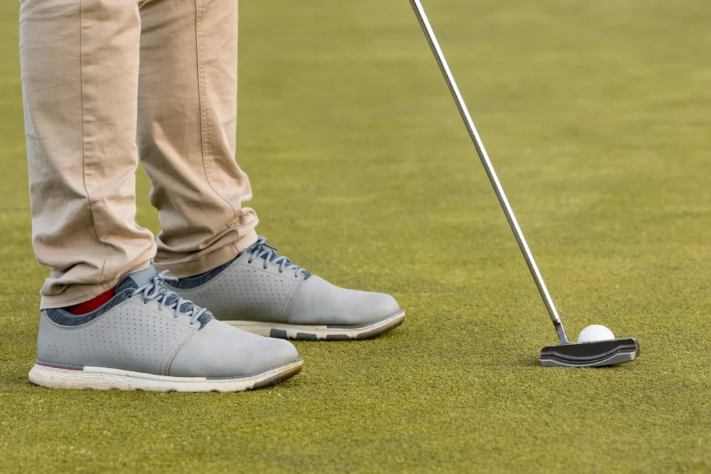 Jugador utilizando un putter Anser para golpear la bola en el green, mostrando técnica y precisión.
