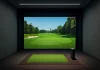 Simulador de golf con pantalla digital mostrando un campo de golf virtual.