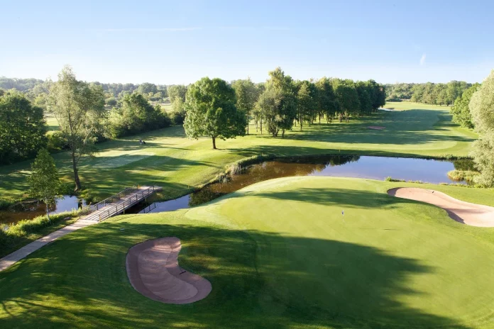 Vista aérea del green del hoyo 9 con bunker y lago en el Golfclub München Eichenried