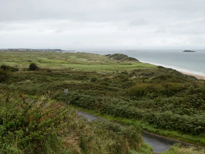 Vista panorámica del campo Royal Portrush con dunas, greenes elevados y mar de fondo